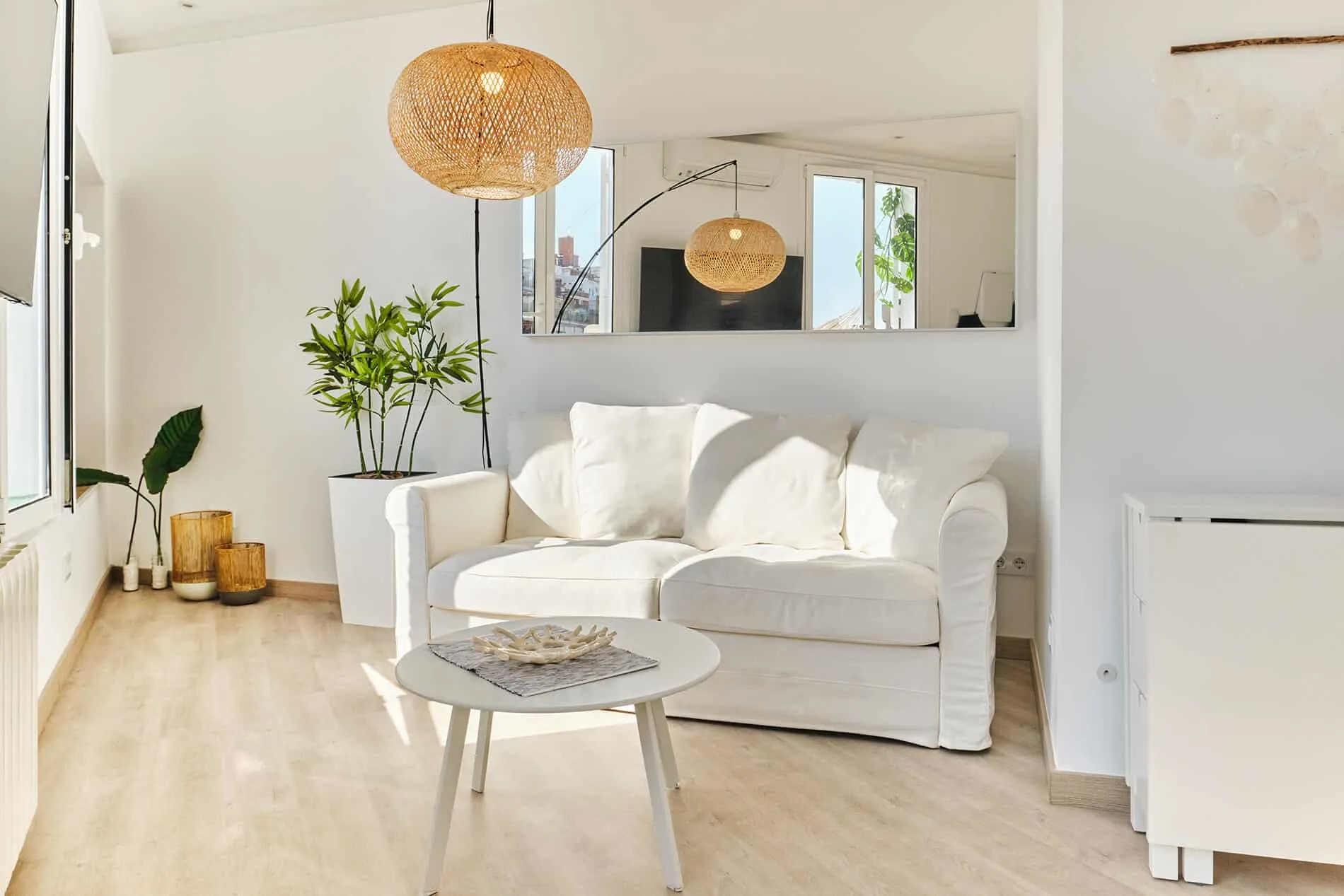 Barcelona roof studio - second-floor studio, living room area with a horizontal mirror above the couch, designed by Beatrice Leupold