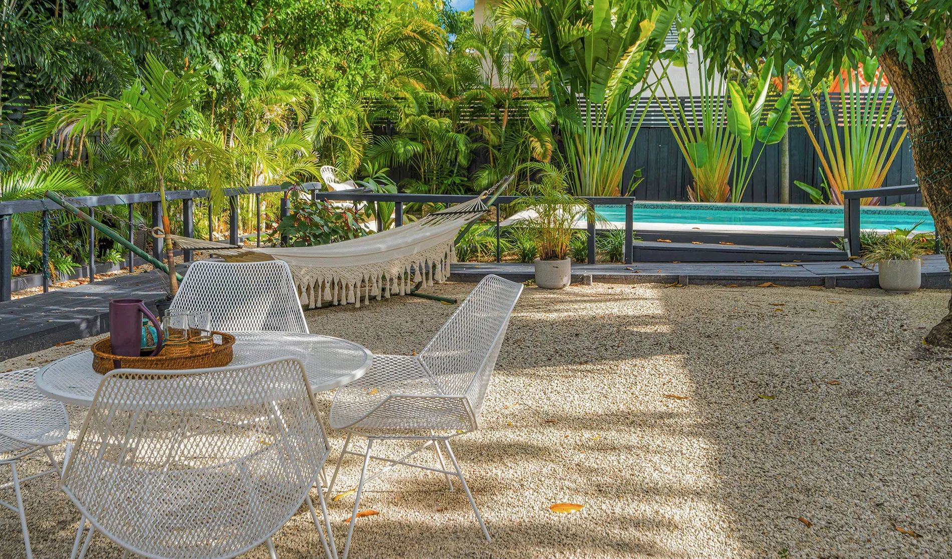 Coconut Grove home renovation - backyard with a pool and seating area, designed by Beatrice Leupold