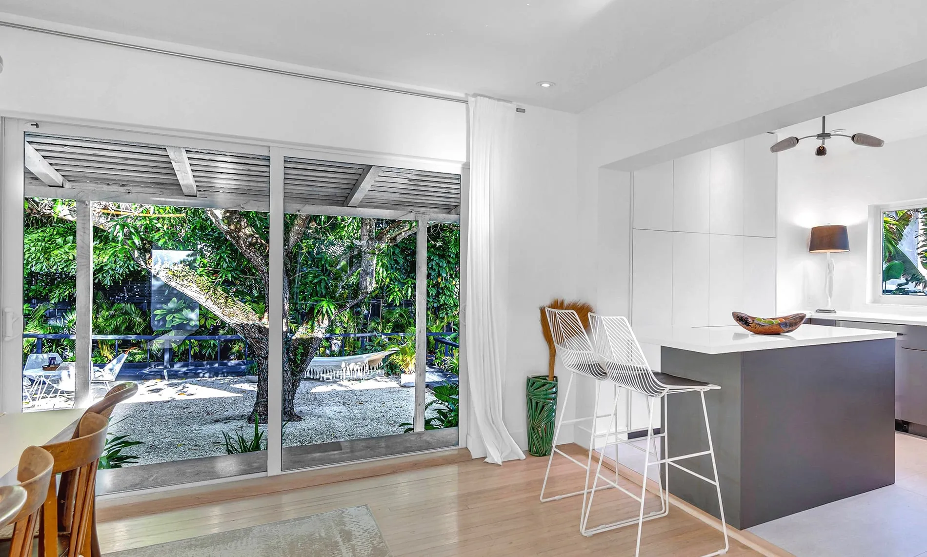 Coconut Grove home renovation - kitchen area with a sliding door to the backyard designed by Beatrice Leupold