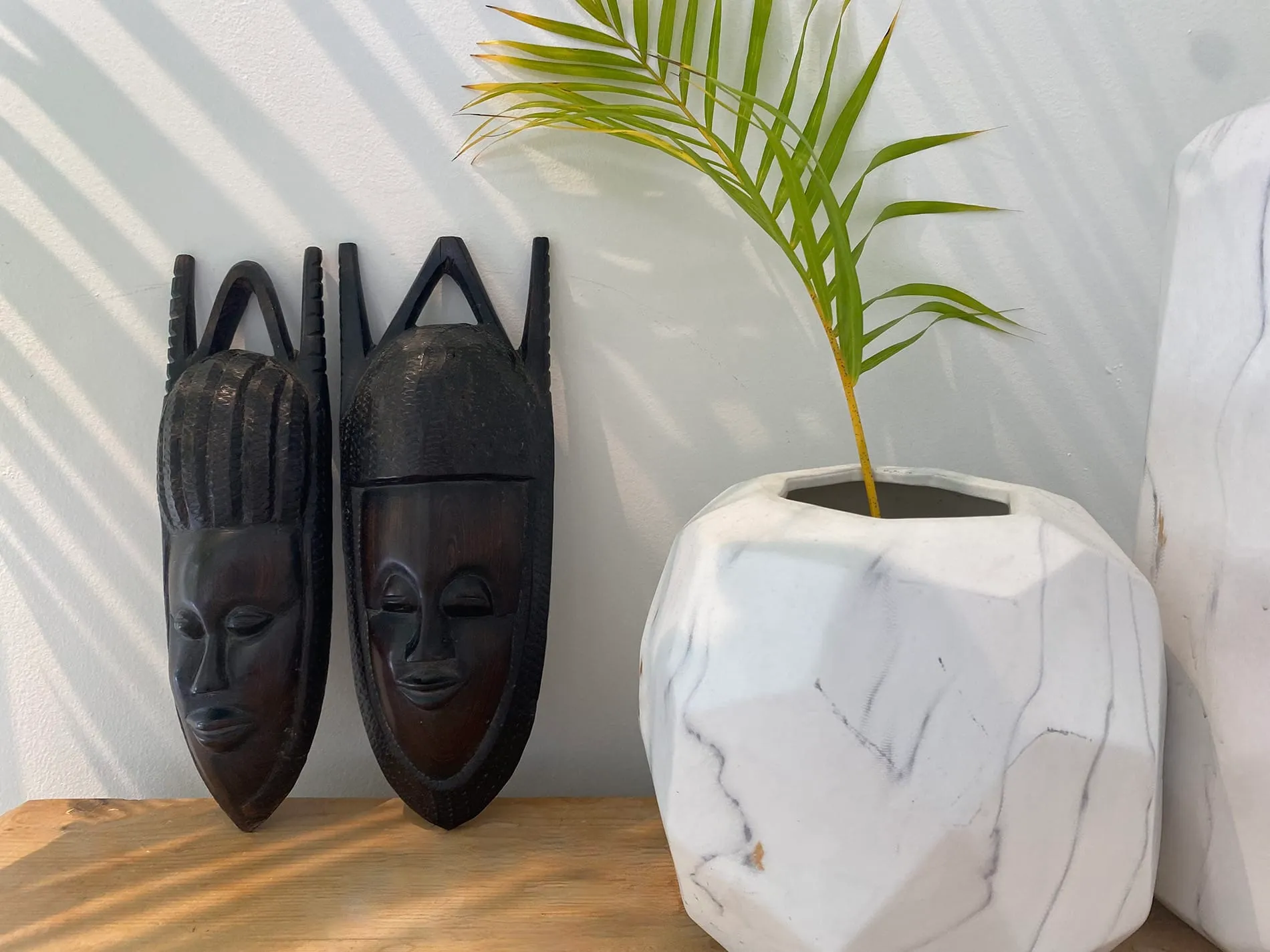 Coconut Grove home renovation - corner table decorated with two wooden faces, designed by Beatrice Leupold