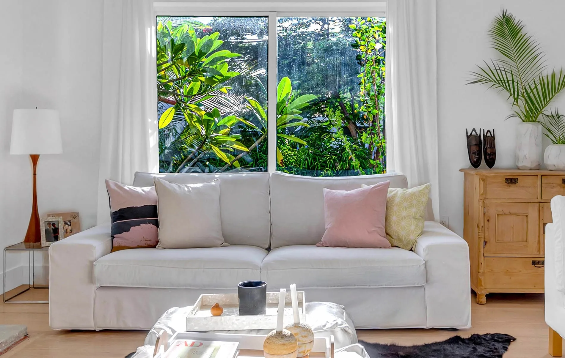 Coconut Grove home renovation - living room couch with a big window behind, designed by Beatrice Leupold
